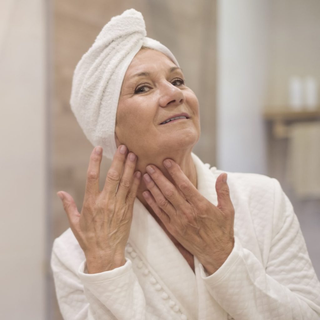 Attractive senior woman browsing in the mirror